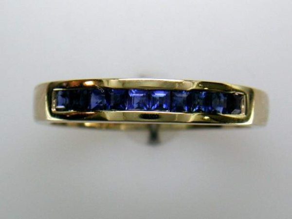 14K YELLOW GOLD SAPPHIRE BAND THAT CONSISTS OF 10 SQUARE SAPPHIRES WEIGHING A TOTAL OF 0.53 CARATS.