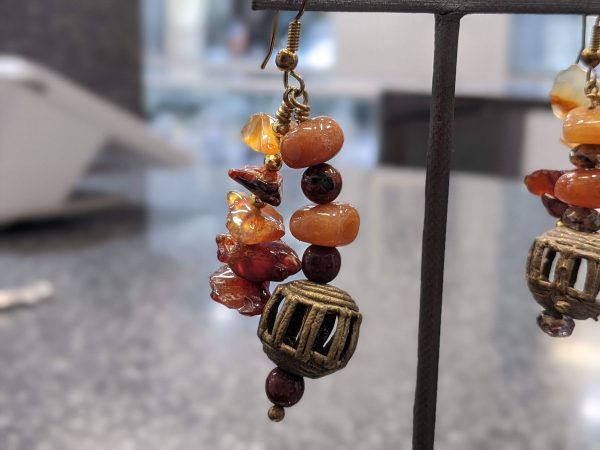 ASSORTED HARD STONE EARRINGS WITH METAL PIECES IN BETWEEN AND A METAL LANTERN SHAPED PIECED AT BOTTON OF EACH EARRING. HAS A NECKLACE TO MATCH.