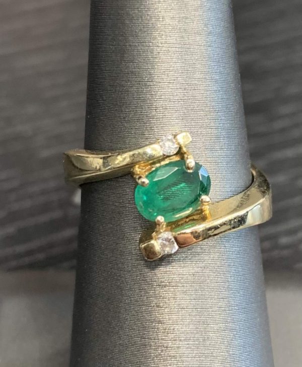 14K YELLOW GOLD EMERALD & DIAMOND RING FEATURING ONE OVAL SHAPE EMERALD AND 0.6 PTS OF ROUND BRILLIANT CUT DIAMONDS. 3.4 DWT