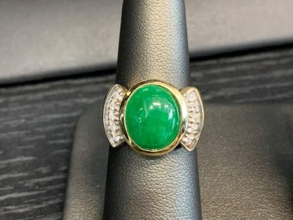 14K Y/G DIAMOND AND EMERALD RING FEATURING ONE OVAL SHAPE CABOCHON EMERALD AND .15 PTS OF ROUND BRILLIANT CUT DIAMONDS. 7.6 DWT