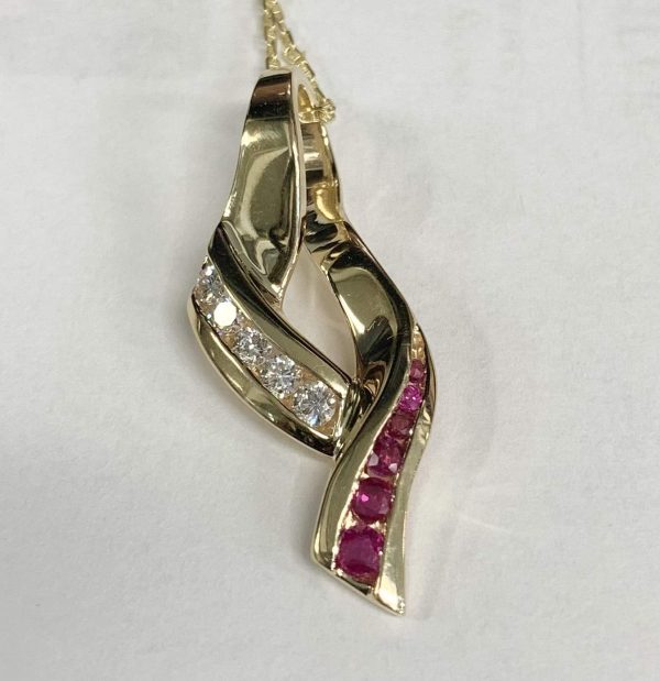 14K Y/G LADIES DIAMOND AND RUBY PENDANT CONSISTING OF 5 RBC DIAMONDS WEIGHING .25 PTS AND 6 RBC RUBIES WEIGHING .25 PTS. GOLD WEIGHT:3.0 DWT.