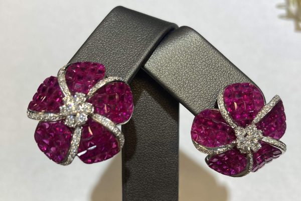 14K W/G, RUBY & DIA FLOWER EARRINGS FEATURING 0.54PTS OF RBC DIA & 6.90 CTS OF INVISIBLE SET PRINCESS CUT RUBIES. FOLDABLE POSTS/OMEGA BACK, 12.3 DWT
