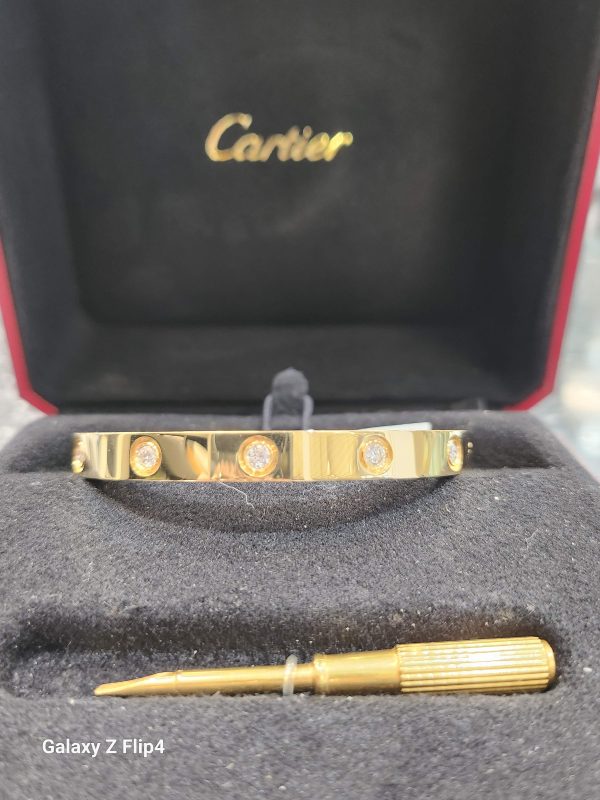 18K YELLOW GOLD CARTIER SIZE 17 -DIAMOND LOVE CUFF BANGLE BRACELET FEATURING 10 ROUND BRILLIANT CUT DIAMONDS (0.10 PTS EA) TOTAL 1.00 CARATS. 6.2MM WIDTH AND 2MM THICK. COMES WITH ORIGINAL RECEIPT & BOX.