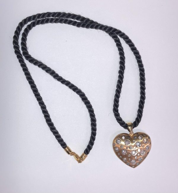 14K 2-TONE HOLLOW HEART STYLE DIAMOND PENDANT FEATURING 0.78 PTS OF NATURAL ROUND BRILLIANT CUT DIAMONDS AND W/G PLAIN PUFFY HEART STYLE ON REVERSE SIDE. PENDANT COMES ON A 26" TWIST/ROPE STYLE CORD. 9.5 DWT.