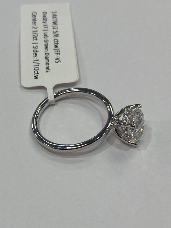 14K WHITE GOLD ENGAGEMENT RING CONTAINING 17 LAB GROWN DIAMONDS W/ A HIDDEN HALO, CENTER STONE IS A ROUND BRILLIANT 2.50 CTS COLOR: F CLARITY: VS, SIDE STONES 0.10 CT COLOR: E-F CLARITY: VS, 2.1 DWT, COMES W/ IGI CARD, IGI# 33J719712405
