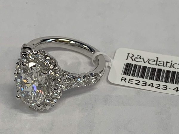 14K WHITE GOLD ELEGANT ENGAGEMENT RING W/ HALO CONTAINING 35 LAB GROWN DIAMONDS. CENTER STONE IS AN OVAL BRILLIANT WEIGHING APPROX 3.06 CTS. COLOR: F, CLARITY: VS, SIDE STONES ARE ROUND BRILLIANT CUT 1.31 TCW, COLOR: E-F, CLARITY: VS, IGI# 35J818492405